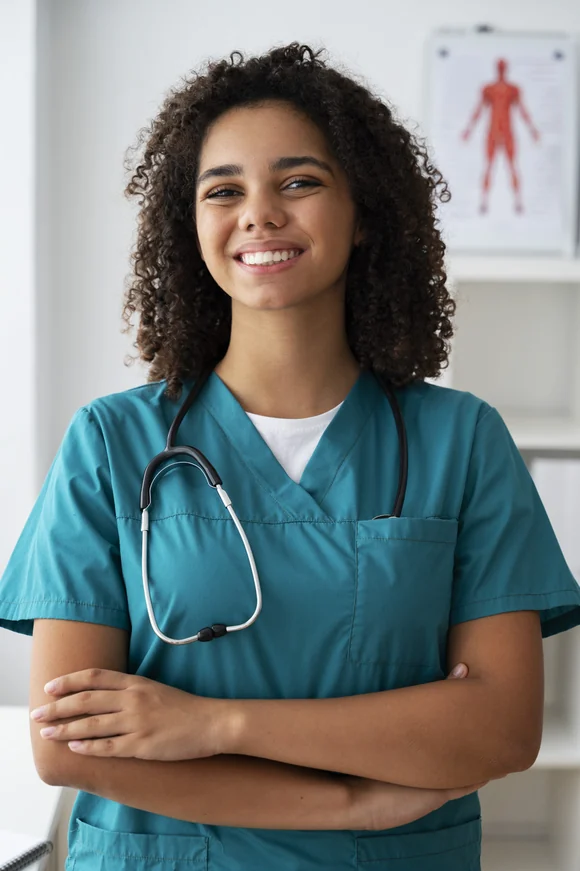 A nurse in scrubs smiling to camera