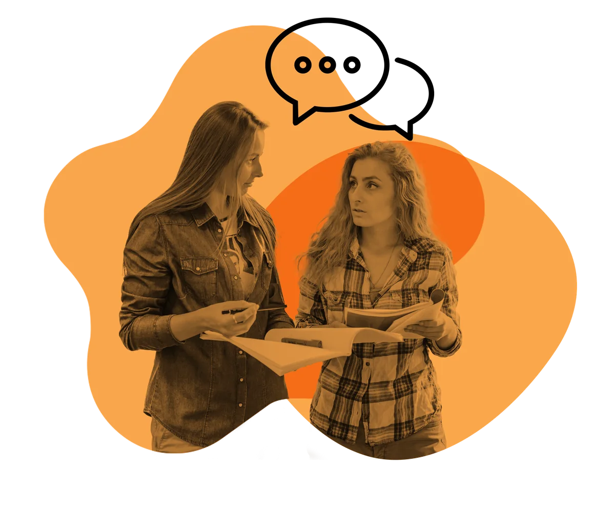 Two teachers talking over a folder of paperwork